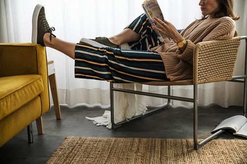 Kvinde læser et blad i en lænestol