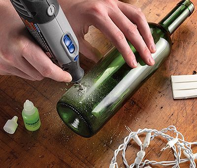 Person borer i glasflaske for at vise, at man kan bore i forskellige materialer