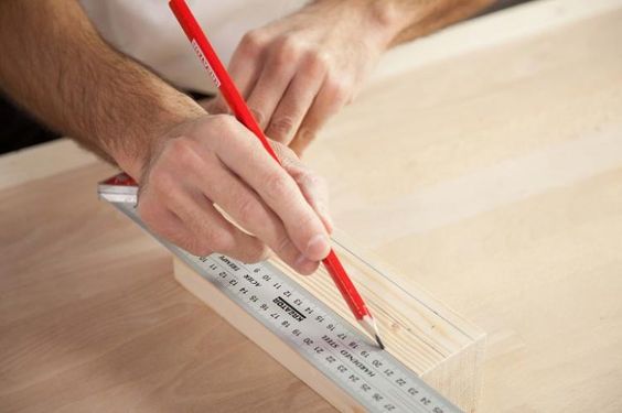 Mand måler op for at bore i forskellige materialer