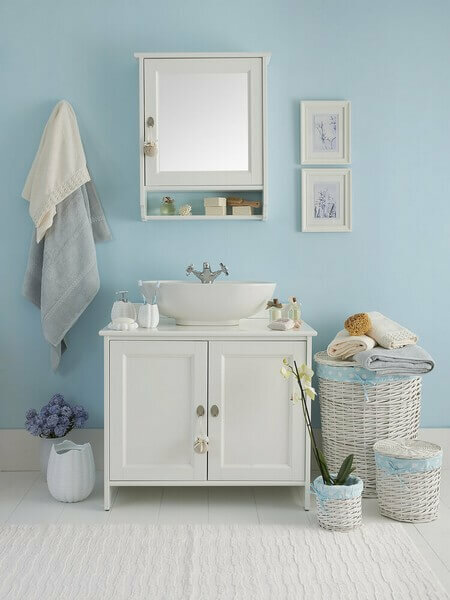 Blåt badeværelse med kunst på væggen