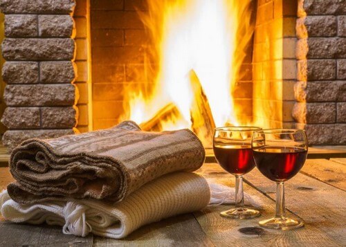 Vinglas og tæpper foran pejsen