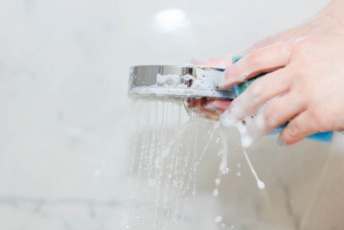 Person rengør brusehoved